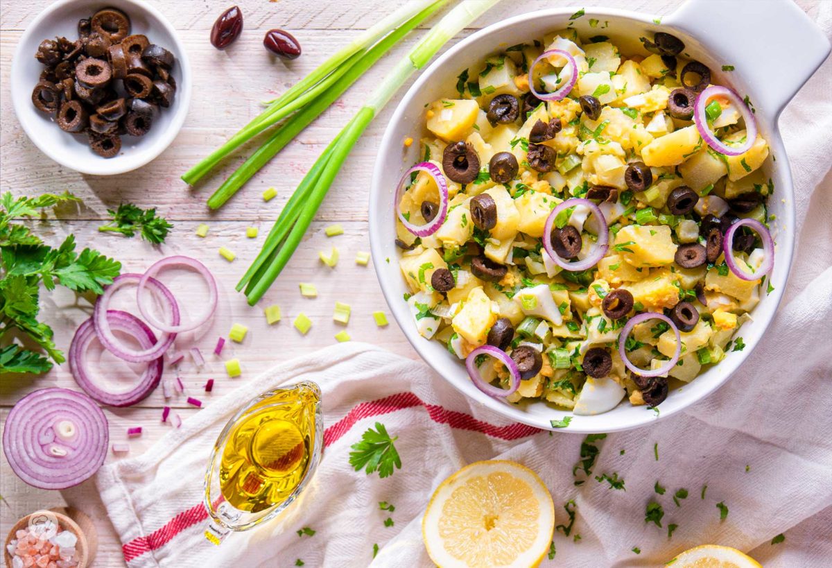 картофена салата снимана отгоре декорирана с маслини лук и зехтин
