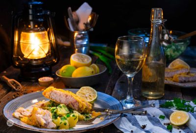 Пържен сом с картофи, поднесен на романтична вечеря с чаша бяло вино