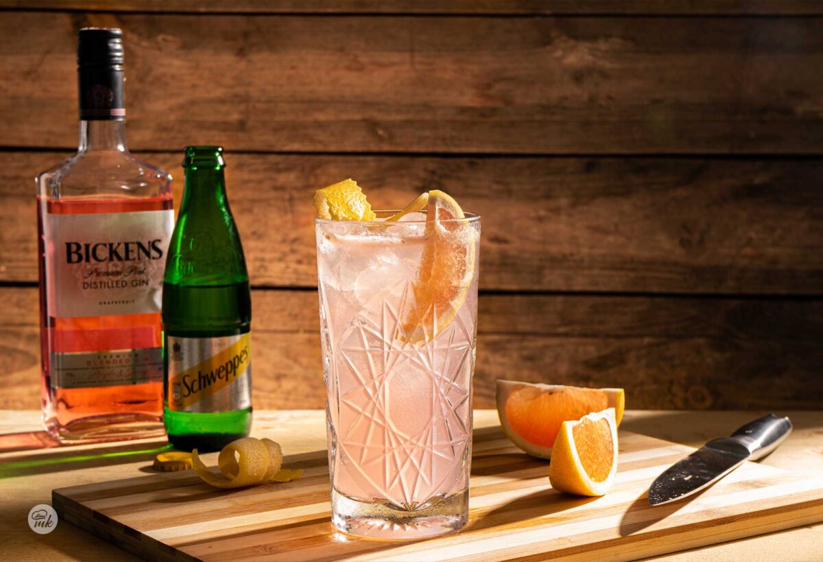 Кристална чаша с коктейл, розов джин и швепс