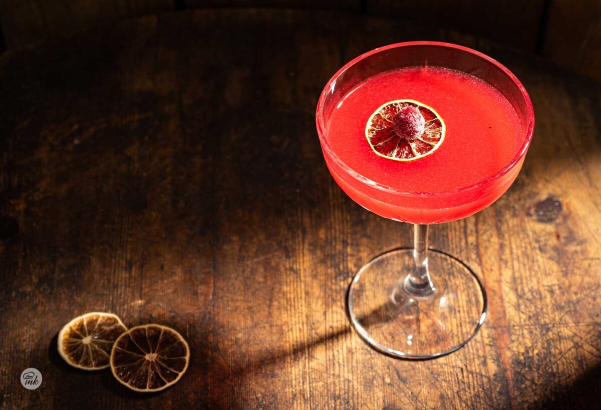 Стъклена чаша със столче, с червен коктейл малиново дайкири