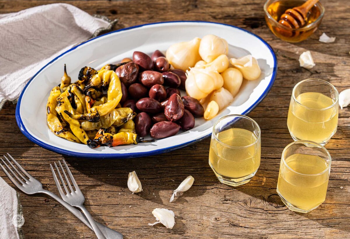 Три чашки греяна ракия с мед и джинджифил, поднесени с туршия и маслини
