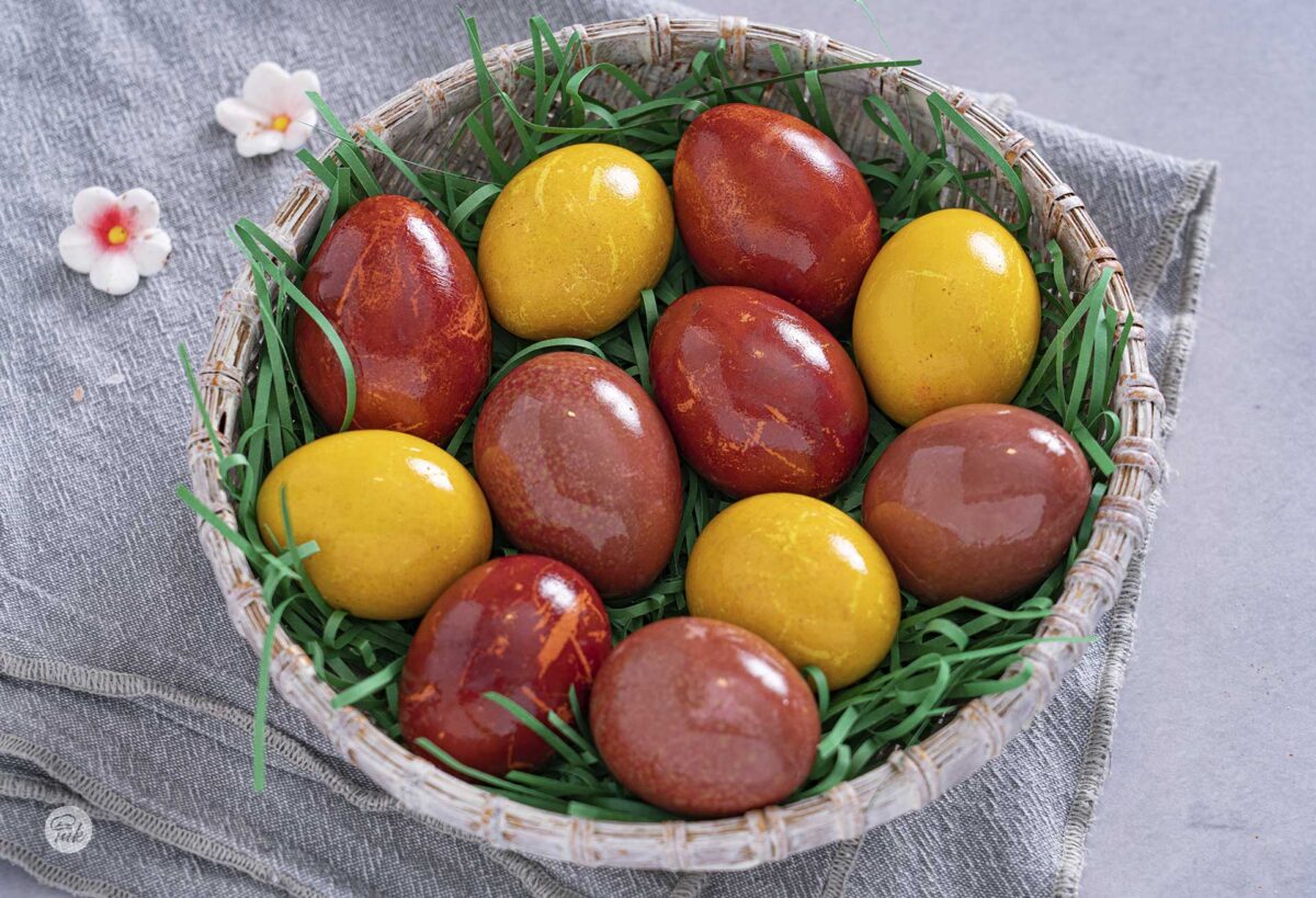 Великденски яйца, боядисани с естествени бои, в кошничка, снимани отгоре