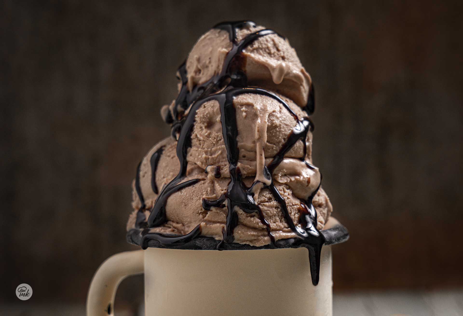 Шоколадов сладолед в метално канче, полят с шоколадов топинг, снимано отпред