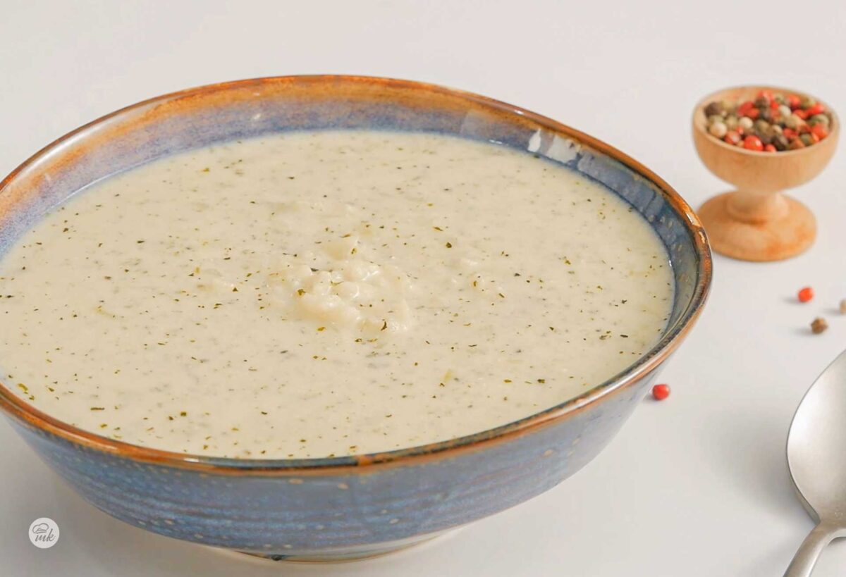 Супа с кисело мляко, мента и ориз в широка синя купичка, снимана отдясно