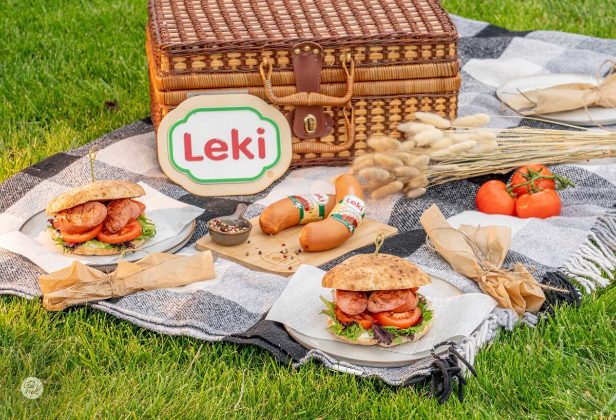 Бургер с македонска наденица Leki върху покривка на тревата, сниман отпред