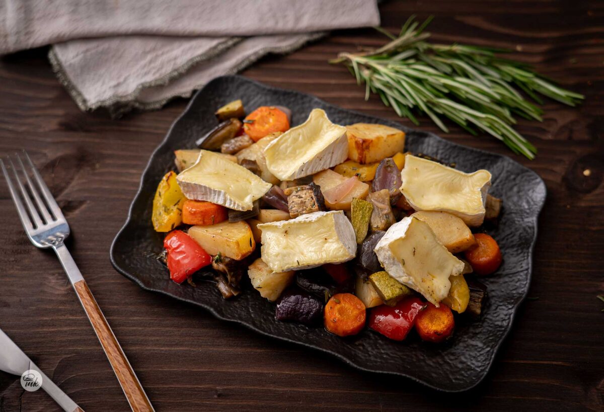 парченца сирене бри със зеленчузи на фурна в черна правоъгълна чиния